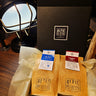 Alfie & Co. Alba and London 1965 coffee bags nestled in tissue paper within a sleek black gift box, featuring our logo. This image showcases our premium coffee gift sets, perfect for any coffee lover. Give the gift of hand-roasted, small-batch coffee from Killearn, Scotland, available for UK delivery at www.alfiecoffee.co.uk. Highlights the thoughtful presentation and quality of our coffee gifts.